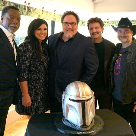 Jon Favreau and others are posing with a Bobba Fett head shaped cake.
